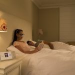 Frau sitzt im Bett und nutzt den AirCurve 10 S