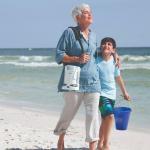 Oma mit Enkel am Strand. Sie trägt über ihrer Schulter den FreeStyle Comfort V2.